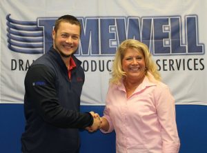 Darren Wagner (left) and Dawn Lucas (right) shake hands after announcing Timewell's purchase of Midwest Plastic Products. 