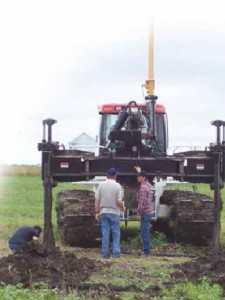 In 2008, ADI owner Don Colclasure (standing left) and a longtime crew foreman review an initial prototype of the Dual Force Technology drainage plow.